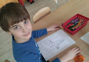 Chłopiec z kolorowanką przedstawiającą Kufer Reymonta